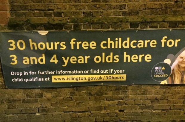 Poster on a wall reading "30 hours free childcare for 3 and 4 year olds here"