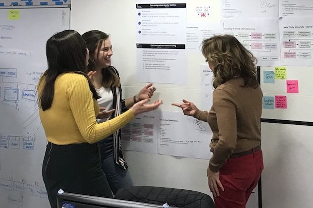 A team discuss their work at their team wall