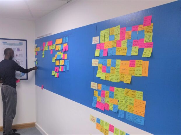 A team member putting post-its on an 'agile' wall