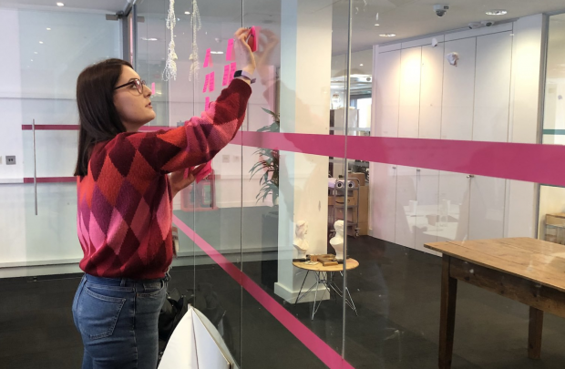 Jessie Fergusson creating an agile wall on a glass panel