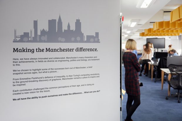 A photo of our feature wall in our Manchester office titled 'Making the Manchester difference'. There are four short paragraphs about how Manchester has always innovated and collaborated and highlighting the successes of Manchester such as Alan Turing and Emmeline Pankhurst. 