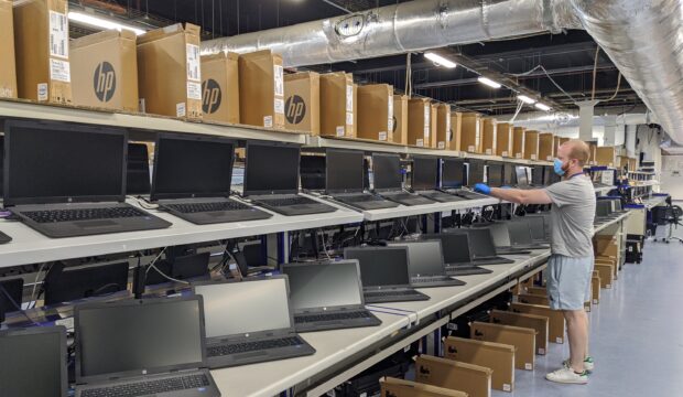 Shelves in a warehouse stacked with laptops