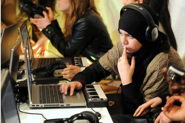 School girl working at a computer during a music class