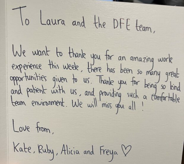 a card reading 'To Laura and the DfE team, we want to thank you for an amazing work experience this week, there has been so many great opportunities given to us. Thank you for being so kind and patient with us, and providing such a comfortable team environment. We will miss you all! Love from Kate, Ruby, Alicia and Freya <3 '